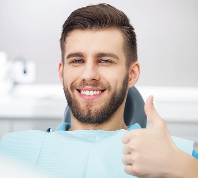 Man in dental chair giving thumbs up