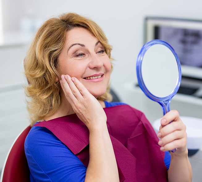 Woman looking at smile in mirror