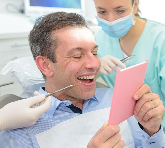 Man looking at smile after full mouth reconstruction