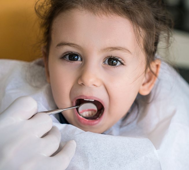 Dentist checking child's smile after dental sealant placement