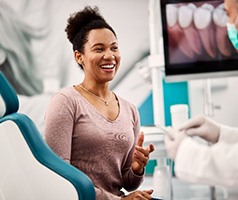 Smiling woman talking to dentist about treatment options