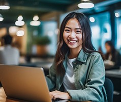 Smiling woman working on laptop at office