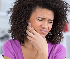 Woman with toothache holding cheek