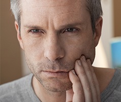 Man with lost filling holding jaw