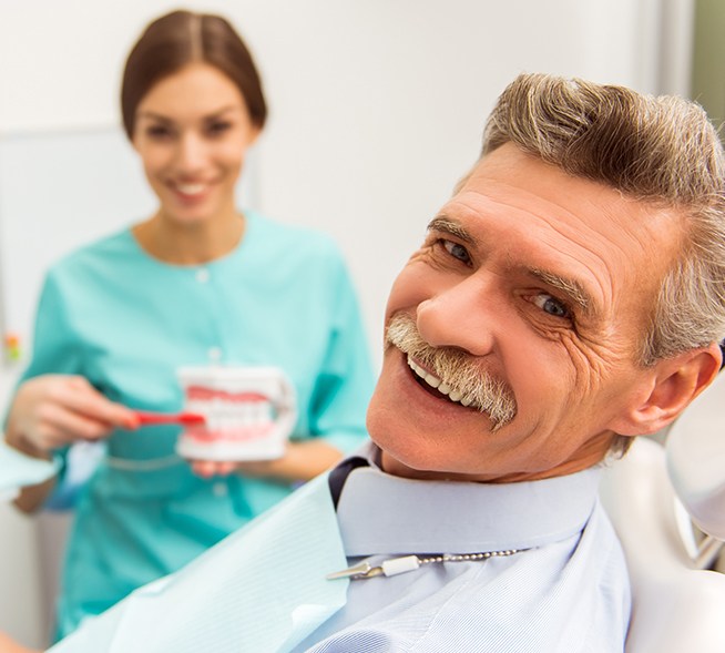 Man smiling in dental chair after emergency dentistry