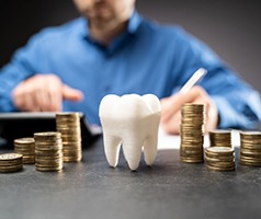 An up-close view of a tooth mold and stacks of coins surrounding it