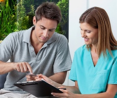 A male patient and female dental employee discussing alternative payment options 