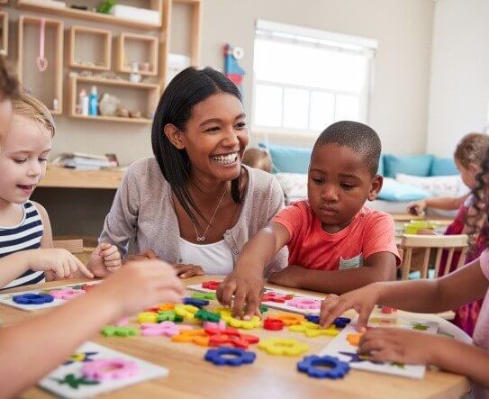 Teach and students playing game around a table