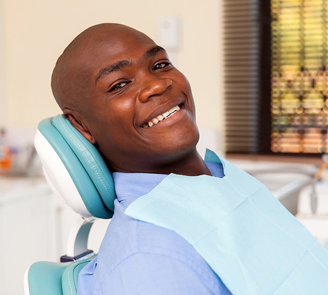 Man in dental chair smiling during dental checkup