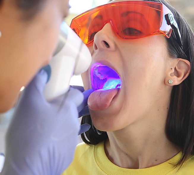 Dentist performing oral cancer screening