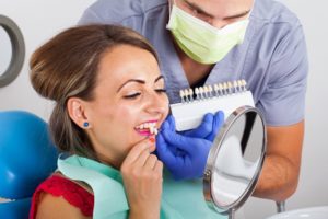 woman wearing red shirt and trying on veneers in Mt. Dora 