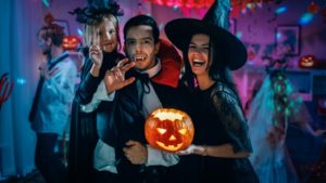 A child and her parents smiling during a Halloween party