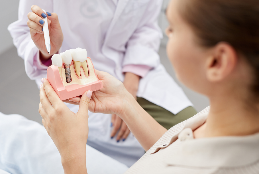 Dentist showing patient model of dental implant