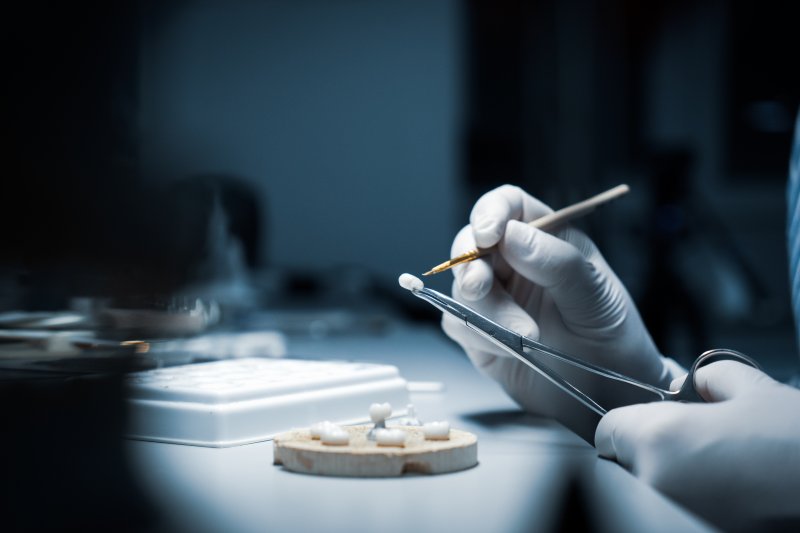 A lab worker crafting a dental crown